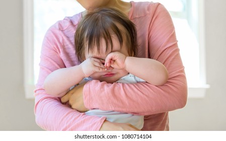 Upset Toddler Boy Crying While Being Comforted By His Mother