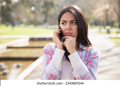 Upset unhappy girl discussing bad news on phone. Young woman in casual speaking on cellphone with sad face. Communication or bad news concept - Powered by Shutterstock