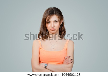 Upset woman with displeased face expressionarms crossed isolated on light gray wall background. Human emotion feeling body language life perception attitude