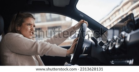 Upset woman driving her car in a city.
