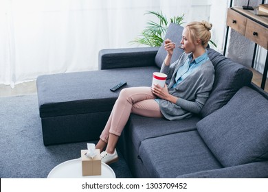 Upset Woman Eating Ice Cream While Siitng On Couch At Home Alone