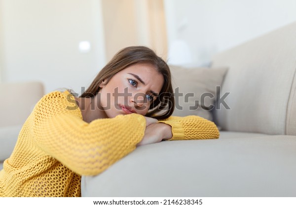Upset woman\
frustrated by problem with work or relationships, sitting on couch,\
covered face in hand, feeling despair and anxiety, loneliness,\
having psychological\
trouble