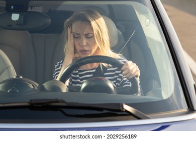 Upset Woman Of Middle Age Looking At Car Dashboard. Anxious Female Driver In Broken Car Out Of Fuel Or Petrol. Stressed Female Forget To Fill Tank For Long Ride Or Road Trip. Troubles Failure Concept