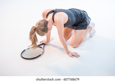 Upset Woman With Tennis Racket Sitting On Floor With Head Down Isolated On White