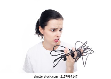 Upset Woman In A White T-shirt Holding A Wire In Her Hand, White Background. High Quality Photo