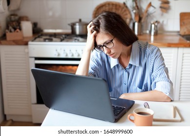 Upset Woman Working From Home Office. Unhappy Freelancer Using Laptop And The Internet. Workplace In Cozy Kitchen. Concept Of Female Business And Career, Housekeeping, Stress. Lifestyle Moment.