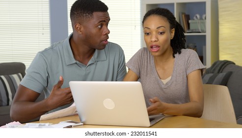 Upset Young Black Couple Arguing Over Bills And Finances With Laptop