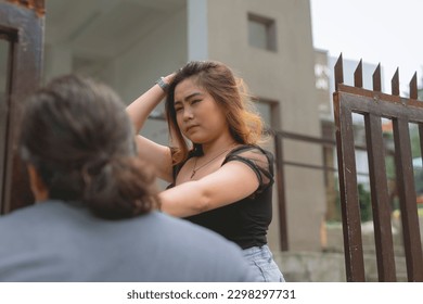 An upset young lady slaps her boyfriend in the face. Denying him entry into their home. Breakup scenario of a live-in couple. - Shutterstock ID 2298297731