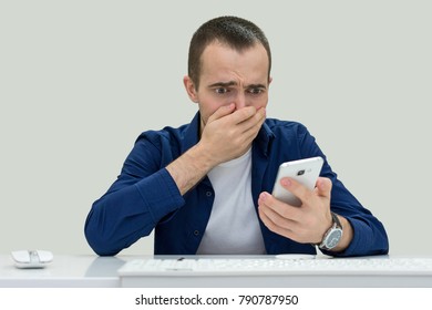 Upset Young Man Looking At Phone, Front View, Looking At Camera