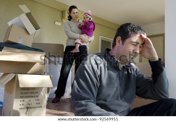 Upset young parents and their daughter outside\
their home.Divorce, homelessness, eviction, unemployment, financial\
issues, marriage problem, child custody and family issues.Real\
people. Copy space