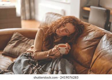 An upset Young Woman lying down on a sofa and speaking by phone in the living room - Powered by Shutterstock