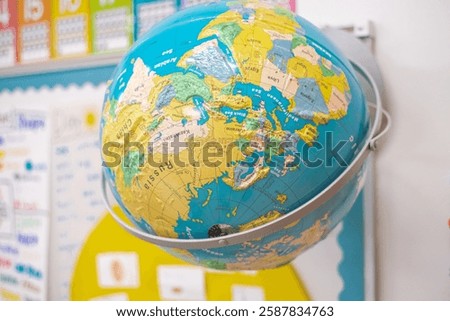 Upside down display of globe raised relief in kindergarten classroom elementary school in Dallas, Texas, colorful, multi-dimensional geographic world map, political boundaries, capitals, oceans. USA