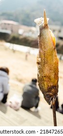 Upside Down Grilled Fish With Bamboo Stick Traditional Japanese Street Food At Summer Festival With Blurred Background