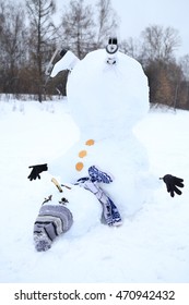 Upside down snowman with grey hat, scarf and skates at winter day