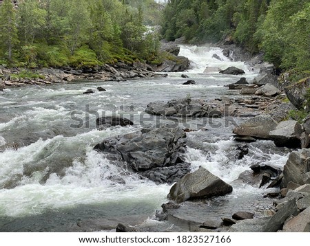 Upstream view of rapid river with rocks in mountain area