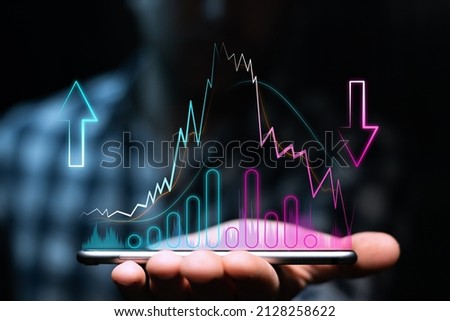 Uptrend and downtrend with high volatility, moving averages and volumes on the phone in the investor's hand. Bullish and bearish chart over trader's phone