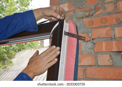 Upvc Window Installation. A Man Is Installing A Self Adhesive Rubber Window Seal Strip, Foam Tape, Or Weather Strip To A Window Frame To Windproof And Soundproof The Window. 