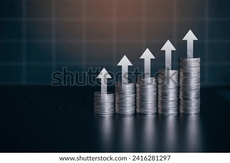Upward stack of silver money coin with white up arrow and percent symbol. Business and financial background concept with copy space. 