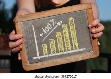 upward trend graph drawn with chalk on writing slate shown by young female