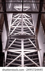 An upward view of the complex steel framework of a modern architectural structure. 
