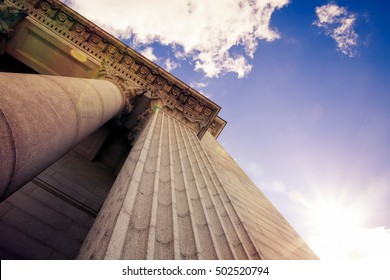 Upward View Of A Court House With Impressive Pillars. Morning Sun Shining Down Creating A Beautiful Lens Flare. Architectural, Construction, Law, Education And Career Concept