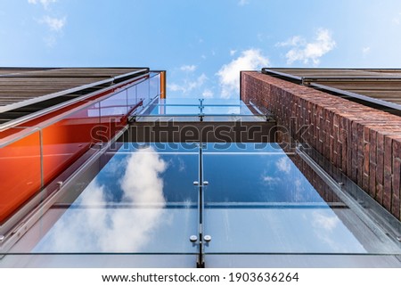 Upward view to to facade of glassy balconies of small building