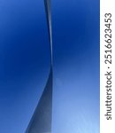 An upward view of the St. Louis Gateway Arch against a clear blue sky. The sleek, curved design contrasts beautifully with the vibrant sky, highlighting the grandeur of this iconic American landmark.