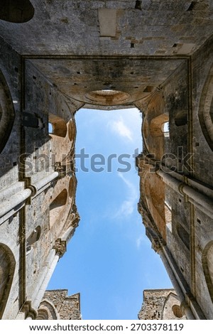Upward view through the roofless Gothic nave of the 13th‑century Cistercian Abbazia di San Galgano near Chiusdino.