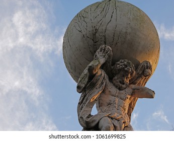Upwards view to statue of Atlas with blue sky with few clouds in the park
