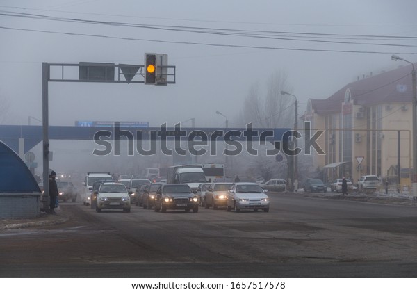 Uralsk, Kazakhstan
(Qazaqstan), 22.02.2020: morning fog in the city, cars stand at the
traffic light waiting for the green light of the traffic light,
туман и автомобили