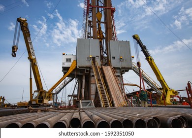 Uralsk Region, Kazakhstan - May 24 2012: Oil Deposit Zhaikmunai. 
Oil Drilling Rig, Oil Workers, Drilling Pipes Cranes And Equipment.