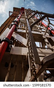 Uralsk Region, Kazakhstan - May 24 2012: Oil Deposit Zhaikmunai. Oil Drilling Rig And Rusted Drilling Pipes And Chain. Upwards View.