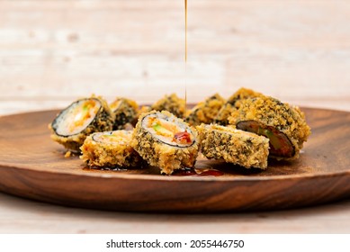 Uramaki Sushi Roll In Panko Tempura Stuffed With Avocado, Salmon And Nori Seaweed Roll With Soy Sauce