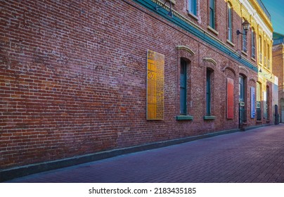 Urban Alley in old city. Old grunge street. Grungy urban background of a brick wall with windows. Travel photo, nobody, copy space for text - Shutterstock ID 2183435185