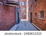 Urban Alleyway with Fire Escape and Barred Windows, Ground Level View