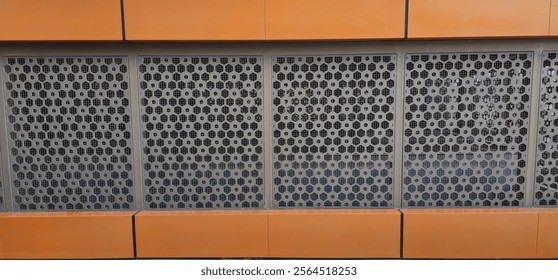 Urban architectural design featuring a hexagonal metal grate pattern on a modern building facade, blending industrial aesthetics with contemporary style, suitable for design and architecture projects.