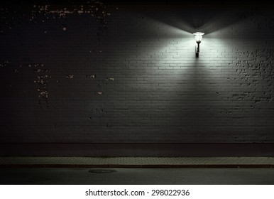 Urban Background. Brick Wall Under The Lamp Light At Night.