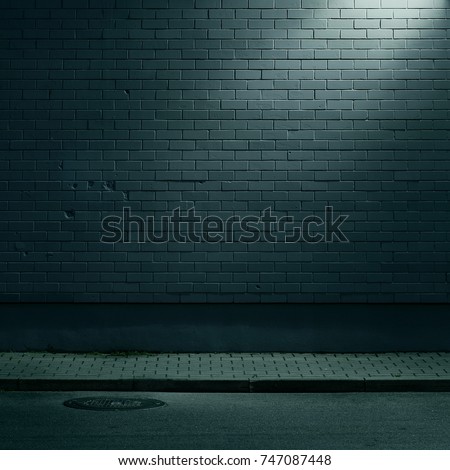 Urban background. Brick wall under the lamp light at night.