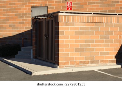 Urban brick wall and trash enclosure - Shutterstock ID 2272801255