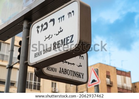 Urban city navigation street name sign, crossroad corner Remez and Jabotinsky in Tel Aviv, Israel