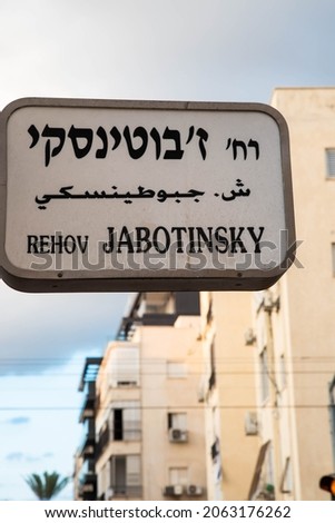 Urban city navigation street name sign, crossroad corner Jabotinsky in Tel Aviv, Israel
