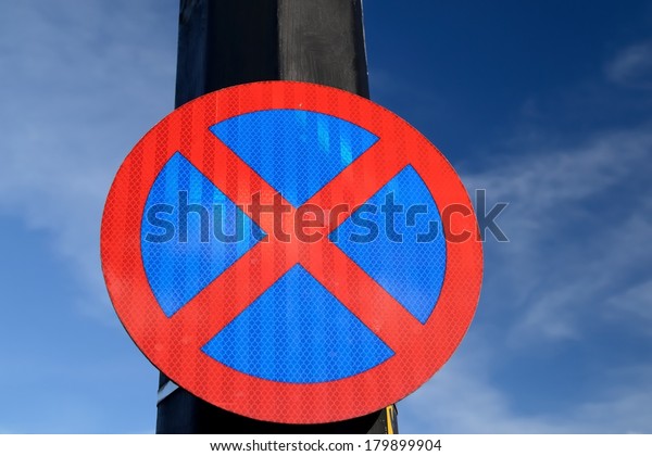 The urban clearway sign with blue skies in\
the background.