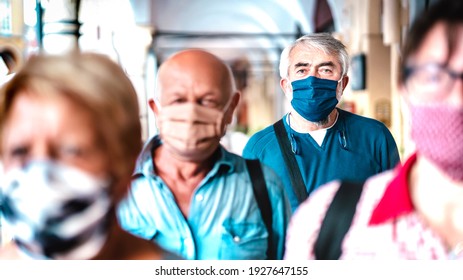 Urban Crowd Of Adult Citizens Walking On City Street During Pandemic - New Reality Life Style Concept With Senior People With Covered Faces - Selective Focus On Man With Blue Protective Mask