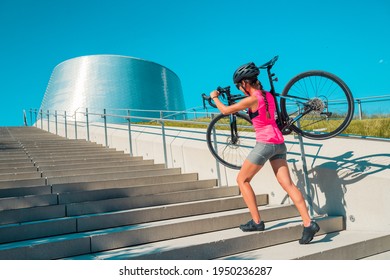 Urban cyclist riding road bike in city carrying bicycle walking up stairs during downtown commute transport travel. - Powered by Shutterstock