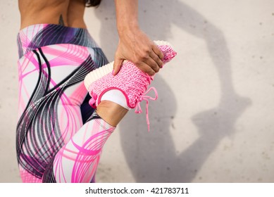 Urban fashion running running sportswear. Female athlete stretching legs after exercising. Healthy lifestyle and sport concept.
