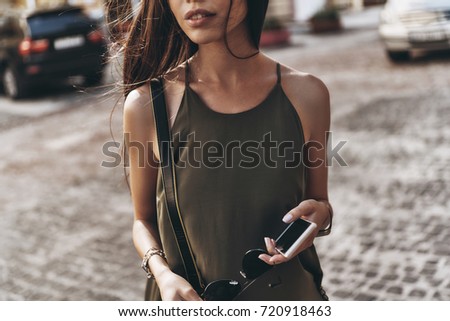 Similar – Woman with earphones listening music in smartphone