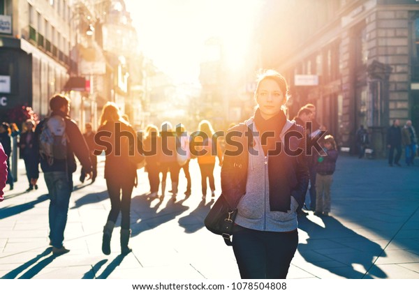 Urban\
girl standing out from the crowd at a city\
street.