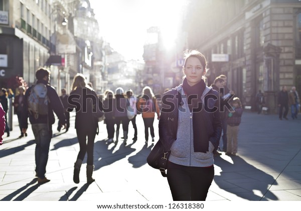 Urban\
girl standing out from the crowd at a city\
street.