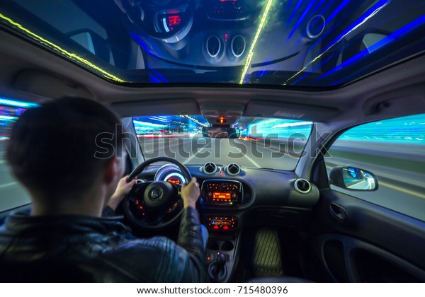 Urban high spees driving on a smal city car with\
panoramic roof. View from inside car natural light street and other\
cars is motion blurred.