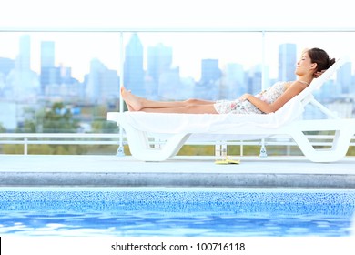 Urban Luxury City Lifestyle Woman Lying By Pool Relaxing In Sun Lounger During Summer In Montreal, Quebec, Canada.